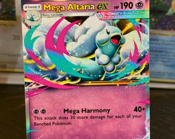 Könnte beinhalten: Eine Mega Altaria EX Pokémon-Karte mit einem hellblauen und rosa Design. Die Karte zeigt ein flauschiges Wesen mit blauem Kopf und einem rosa und blauen Hintergrund. Text enthält "Mega Harmony" und "HP 190".