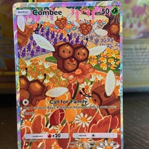 May include: A Combee Pokémon trading card with a colorful floral background. The card features a Combee character with a honeycomb design, surrounded by flowers and bees. Text on the card includes "Combee", "Call for Family", and other game-related details.