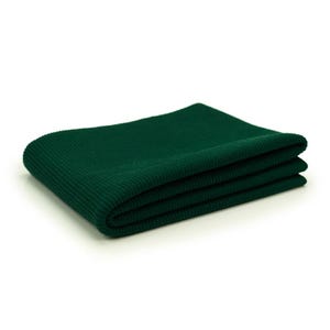 A folded green fabric, possibly a blanket or a scarf, is shown against a white background.