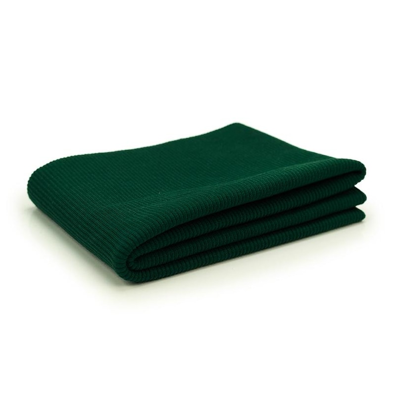 A folded green fabric, possibly a blanket or a scarf, is shown against a white background.