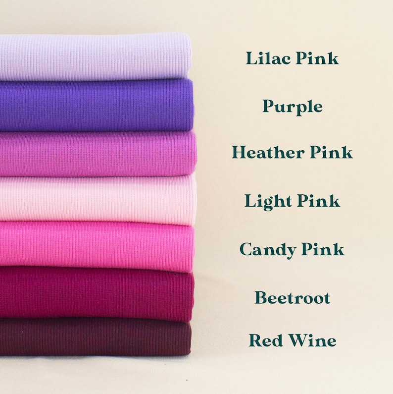 A stack of seven different colored ribbed fabrics, including Lilac Pink, Purple, Heather Pink, Light Pink, Candy Pink, Beetroot, and Red Wine, arranged in a visually appealing manner.
