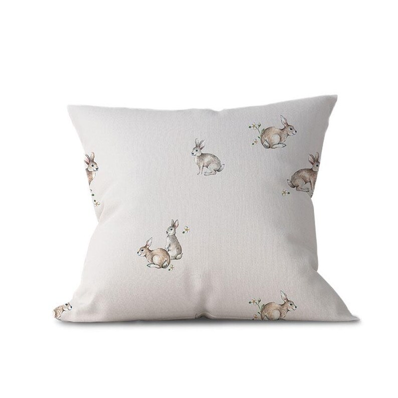 a white pillow with rabbits on it