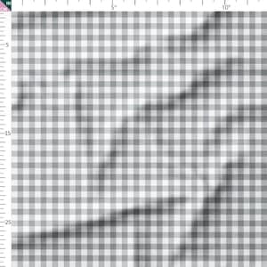 May include: A close-up of a fabric with a gray and white gingham pattern. The fabric is folded, creating shadows and texture. The pattern is a classic, timeless design, often used for clothing, home decor, and crafts.