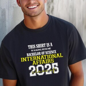 Dieses Shirt ist ein Walking Resume INTERNATIONAL AFFAIRS Klasse von 2025 Comfort Farben Relaxed Fit, Unisex, 100% Baumwolle, vorgeschrumpftes T-Shirt!