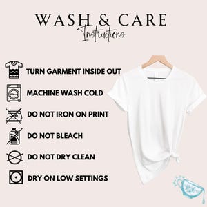 May include: A white t-shirt hangs on a wooden hanger, with care instructions displayed on the left. The text reads "WASH & CARE Instructions" and includes symbols for washing, ironing, and drying. The shirt is knotted at the bottom.