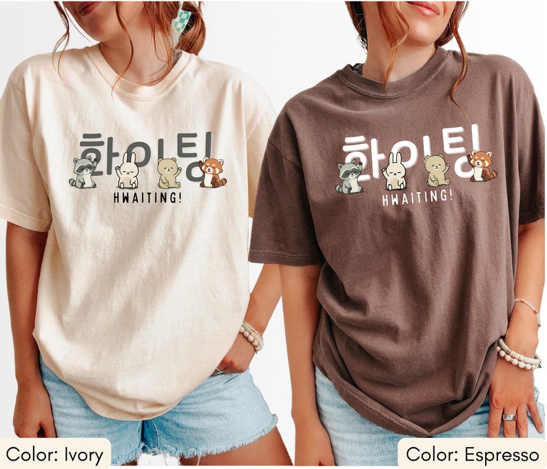 May include: Ivory and espresso-colored t-shirts with a Korean text design and cute animal illustrations. The text reads "HWAITING!" with a raccoon, rabbit, bear, and red panda. The shirts are short-sleeved and have a relaxed fit.