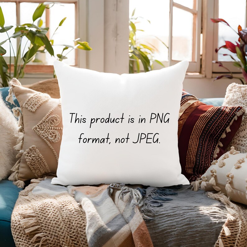 May include: A white square pillow with the text "This product is in PNG format, not JPEG." in black. The pillow is surrounded by other decorative pillows and a blanket, with plants and a window in the background.