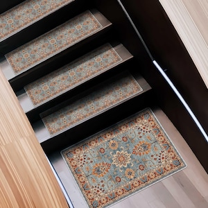May include: A set of stair treads with an ornate, floral pattern in shades of blue, orange, and beige. The treads are rectangular and placed on wooden stairs, creating a decorative and functional element for home decor.