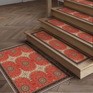 May include: Red and beige patterned stair treads and a matching rug. The treads are installed on wooden stairs. The rug is rectangular with a similar design. The pattern features a central medallion and repeating floral motifs.