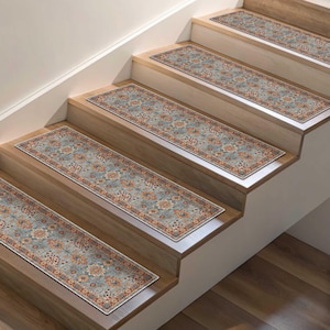 May include: Stair treads with a traditional floral pattern in shades of blue, orange, and cream. The rectangular rugs are placed on wooden stairs, providing a decorative and functional element to the home.