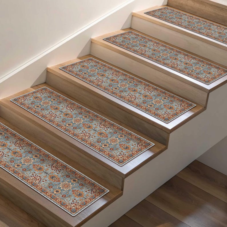 May include: Stair treads with a traditional floral pattern in shades of blue, orange, and cream. The rectangular rugs are placed on wooden stairs, providing a decorative and functional element to the home.