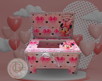 May include: A pink decorative box with a Minnie Mouse theme, featuring a hinged lid and a clear top. The box is adorned with Minnie Mouse bows, hearts, and the text "Happy Valentine's Day". The edges are embellished with rhinestones. Heart-shaped balloons are in the background.