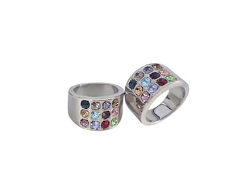 May include: Two silver rings with a square pattern of colorful gemstones. The gemstones are in various colors, including blue, pink, green, and red. The rings are set against a white background.