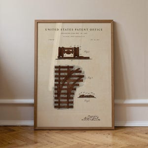 Op de afbeelding: Een ingelijste print van een United States Patent Office document voor de aanleg van spoorwegen. Het beige papier bevat bruine technische illustraties met de labels Fig 1, Fig 2 en Fig 3, voorzien van genummerde onderdelen.