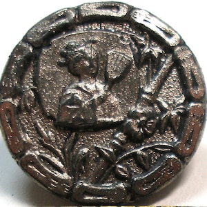 May include: A silver-toned metal button featuring a raised design of a person holding a flower. The button is circular with a raised rim and a textured surface.