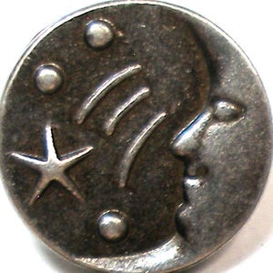 Pode incluir: Um botão redondo de metal prateado com desenhos celestiais. O botão apresenta uma lua crescente, uma estrela de cinco pontas, três linhas curvas e três pequenos círculos. O desenho é em relevo na superfície do botão.