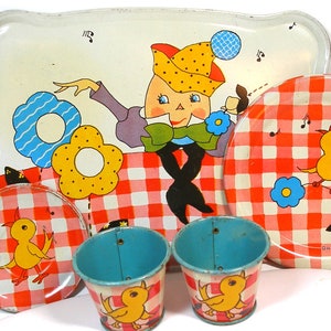 Könnte beinhalten: Ein Vintage-Kinderservice mit rot-weißem Karomuster. Das Set enthält zwei Tassen, zwei Untertassen, einen Teller und ein Tablett. Das Tablett zeigt eine Comicfigur mit Fliege und Blume und einen Vogel auf jedem Teller und jeder Tasse.