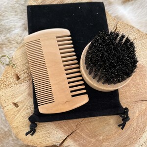May include: A wooden comb and a black bristle brush with a wooden handle, both in a black velvet pouch.