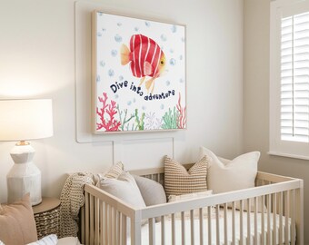 May include: A framed watercolor print featuring a red and yellow striped fish with the words "Dive into adventure." The artwork includes coral and bubbles. The print hangs above a white crib with pillows and a lamp.
