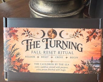 May include: A rectangular black box with a decorative paper sleeve featuring autumn leaves, moon phases, and the text: THE TURNING FALL RESET RITUAL, RELEASE RESET CROSS BEGIN, THE CAULDRON BY THE SEA, every cauldron stirred with purpose, every potion finished with magic.