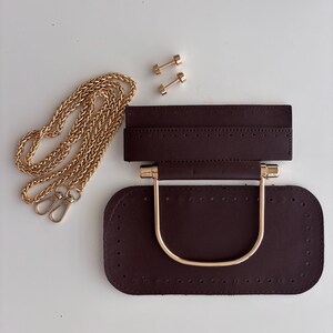 Puede incluir: Base de bolso marr&oacute;n oscuro con asa y herrajes dorados, una cadena dorada y dos remaches dorados. La base tiene agujeros pre-perforados para coser.