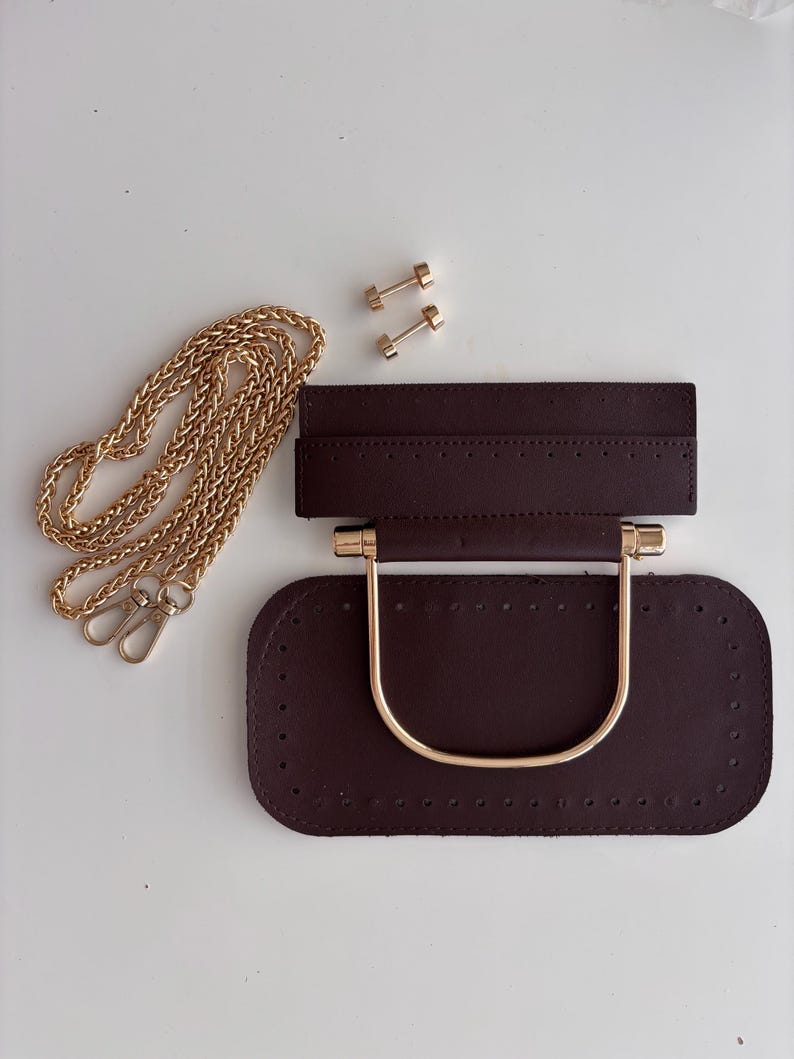 Puede incluir: Base de bolso marr&oacute;n oscuro con asa y herrajes dorados, una cadena dorada y dos remaches dorados. La base tiene agujeros pre-perforados para coser.