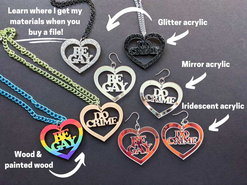 May include: A set of heart-shaped necklaces and earrings with the phrases "Be Gay" and "Do Crime" in various materials, including glitter acrylic, mirror acrylic, iridescent acrylic, wood, and painted wood.