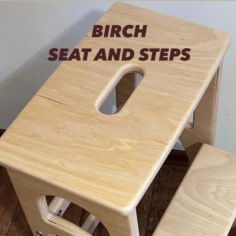 May include: A light-colored birch wood step stool with a rectangular seat and a handle cutout. The text "BIRCH SEAT AND STEPS" is printed on the seat. The stool has a second step below.