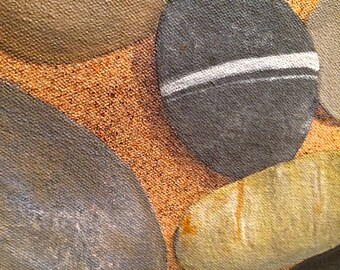 May include: Close-up of a canvas painting featuring several smooth, rounded stones in shades of gray, tan, and yellow. One stone has a prominent white stripe. The background is a textured, sandy color.