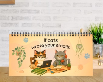May include: A spiral-bound desk calendar with a light orange background featuring the text If cats wrote your emails. The illustration shows two cats at a desk, one wearing glasses using a laptop and the other talking on a red telephone, with a book titled How to Create Chaos.