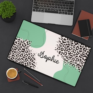 Könnte beinhalten: Eine weiße und grüne Laptop-Haut mit einem Leopardenmuster und dem Namen "Sophie" in schwarzer Schrift.