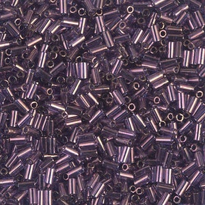 May include: A close-up view of a large quantity of small, iridescent purple glass beads. The beads are cylindrical in shape and have a metallic sheen.
