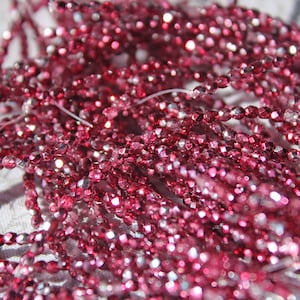 May include: A strand of pink and silver faceted glass beads. The beads are small and have a shiny finish.