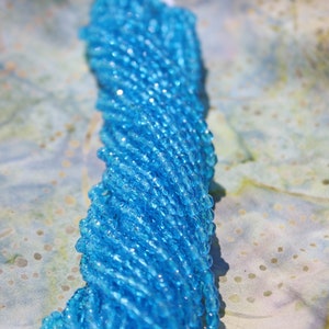 May include: A strand of light blue glass beads, perfect for jewelry making or crafting projects.