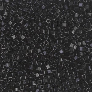 May include: A close-up shot of a pile of small, square, black beads. Each bead has a hole in the center, and they are scattered randomly. The beads have a glossy finish, reflecting light. The overall effect is a dense, textured surface.