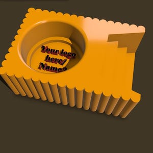May include: A 3D-rendered, orange-colored product with a circular indentation and a stepped design. The text "Your logo here/Name" is visible within the circular area. The product has a scalloped edge.