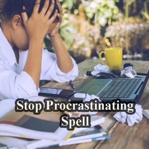 Op de afbeelding: Een persoon zit aan een bureau met een laptop, gekreukt papier en boeken. De tekst "Stop Procrastinating Spell" is zichtbaar op het bureau.