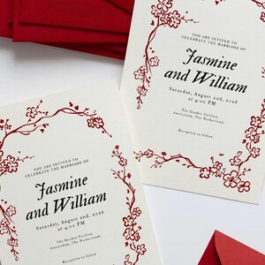 May include: Wedding invitations with floral border and text. The invitations are cream-colored with red floral accents and text that reads "Jasmine and William" and the wedding date and time. Red envelopes are visible.