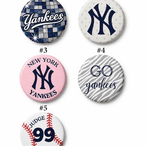 Könnte beinhalten: Eine Sammlung von fünf runden Buttons mit Designs der New York Yankees. Designs umfassen das Yankees-Logo, die Wörter "Yankees" und "Go Yankees" sowie einen Baseball mit der Nummer 99 und dem Namen "Judge".