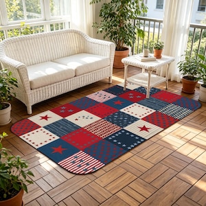 Op de afbeelding: Een rechthoekig vloerkleed met een patchworkontwerp van rode, witte en blauwe vierkanten. Het patroon bevat diverse motieven zoals effen sterren, kleine sterrenclusters, dunne strepen en stippen die in een raster over het oppervlak zijn verdeeld.