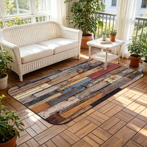 Può includere: Un tappeto rettangolare con un design a doghe di legno invecchiato. Il tappeto presenta un mix di colori tra cui marrone, rosso, blu e grigio, creando un'estetica rustica. È posizionato su un pavimento in legno, vicino a un divano in vimini bianco e un tavolino.