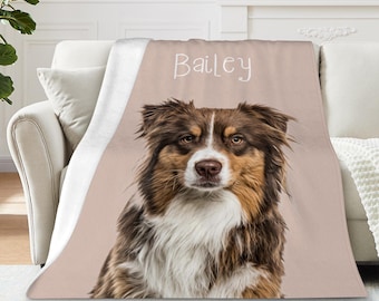 Könnte beinhalten: Eine personalisierte Decke mit einem Hundeporträt. Der Hund hat braunes, weißes und schwarzes Fell. Der Name "Bailey" ist in Schreibschrift geschrieben. Die Decke ist über ein weißes Sofa drapiert. Der Hintergrund ist hellrosa.