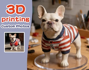 May include: A 3D-printed figurine of a white French Bulldog wearing a red and white striped shirt with navy blue trim. The figurine is on a clear, round stand. The image also includes the text "3D printing Custom Photos".