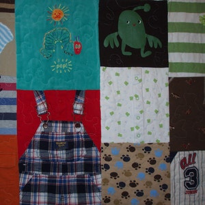 May include: A patchwork quilt with various fabrics and patterns, including a green fabric with a caterpillar and the word "POP!" embroidered on it, a red fabric with a pair of blue and white plaid overalls, and a brown fabric with paw prints.