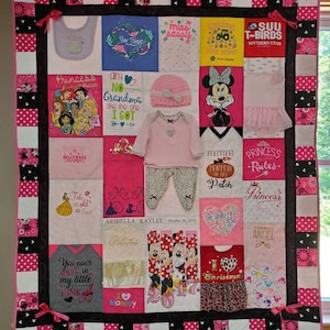 May include: A pink and black patchwork quilt with a variety of appliqued designs, including a princess, a Mickey Mouse, a pumpkin, and a Christmas tree. The quilt is made of a variety of fabrics, including cotton, flannel, and fleece. The quilt is decorated with a variety of embellishments, including ribbons, buttons, and beads. The quilt is personalized with the name "Aribella Kaylee" and the date "October 26, 2015".