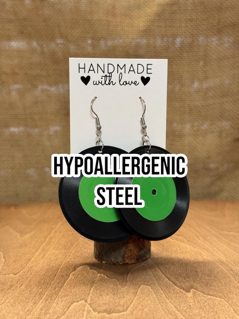 May include: A pair of black and green record earrings with hypoallergenic steel hooks. The earrings are handmade with love and feature a green center with a black outer ring.