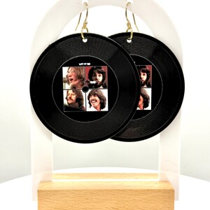 May include: A pair of black vinyl earrings featuring a Beatles album cover with the text "Let It Be".