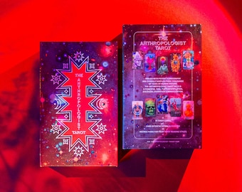 May include: The Anthropologist Tarot deck box features a colorful, cosmic design with a white starburst pattern. The back of the box shows the 78 cards with illustrations inspired by human history.