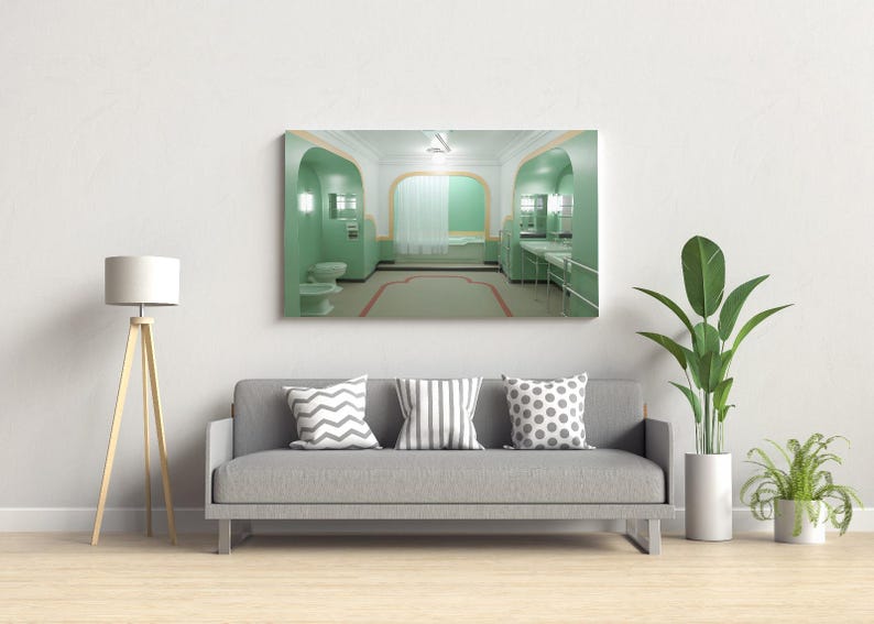 May include: A gray couch with three pillows in a living room setting. The pillows have different patterns: one with a chevron pattern, one with stripes, and one with polka dots. A large framed picture of a green bathroom with a white bathtub hangs on the wall above the couch. A floor lamp with a white shade and a potted plant are also visible in the room.