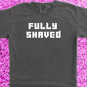 Puede incluir: Una camiseta gris oscuro con el texto "FULLY SHAVED" impreso en blanco.